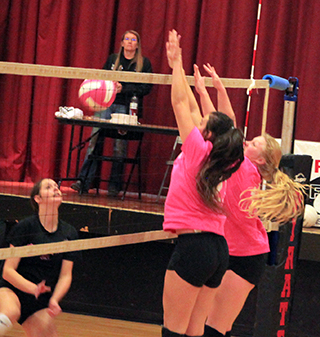 Josie Remacle makes a block against Troy as she and Kristin Wemhoff put up a wall.