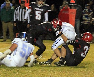 Lane Schumacher and Jessie Cronan tackle Lapwai’s quarterback. Also shown is Trenton Lorentz.