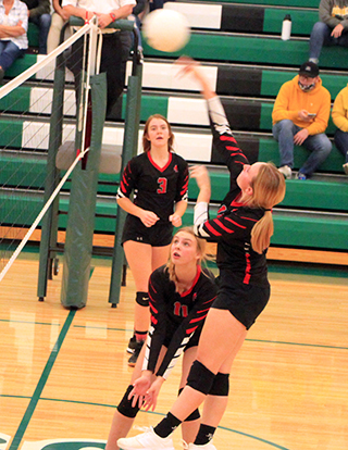Mackenzie Key goes for a spike at Potlatch. Also shown are Tara Schlader and Alli Geis.