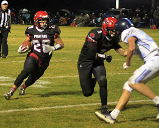 The Prairie Pirates won the battle of league unbeatens against Lapwai 58-26 last Friday. With a win in either of their final 2 games they will clinch their 4th straight White Pine League championship. Shown is Tayden Hibbard about to make the block that springs Brody Hasselstrom for one of his 3 rushing touchdowns.