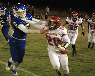 Brody Hasselstrom stiffarms a would-be tackler. Also shown are Quirt Goeckner and Colton McElroy.