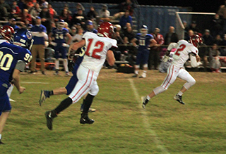 Lane Schumacher heads for the end zone after making an interception. Also shown is Shane Hanson.