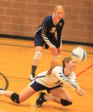 Makayla Rose digs the ball against Timberline as Rachel Sonnen looks on.