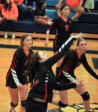 Riley Enneking sends the ball over the net. She had a huge service run in the final game against Lapwai. Also shown from left are Lexi Schumacher, Julia Rehder and Alli Geis.