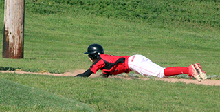 Levi McElroy makes a head first dive into third against Lapwai.