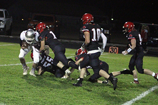 Ben Secrest and Lane Mader tackle C.V.’s quarterback for a big loss. Also shown are Chris Schumacher, Trajan Elven and Ashton Martin.