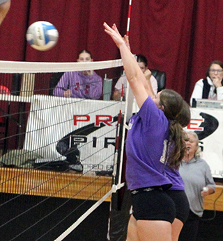 Kylie Schumacher and Harlee Hansen go up to block a Logos spike on Monday.