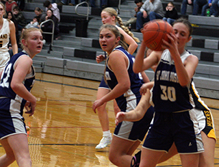 Catherine Beckman grabs a defensive rebound at Highland. Also shown are Madeline Wassmuth, Teagan Dieseldorff and Catherine Seubert. Photo by Steve Wherry.