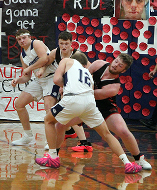 Nate Forsmann forces a jump ball in the Idaho County Shootout game at Grangeville. Also shown is Max Rehder.